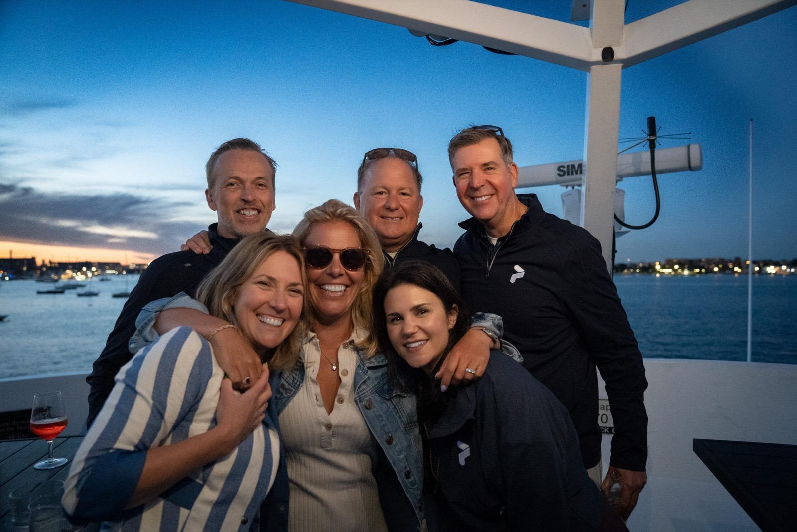 Pixability team members posing together on a boat at sunset