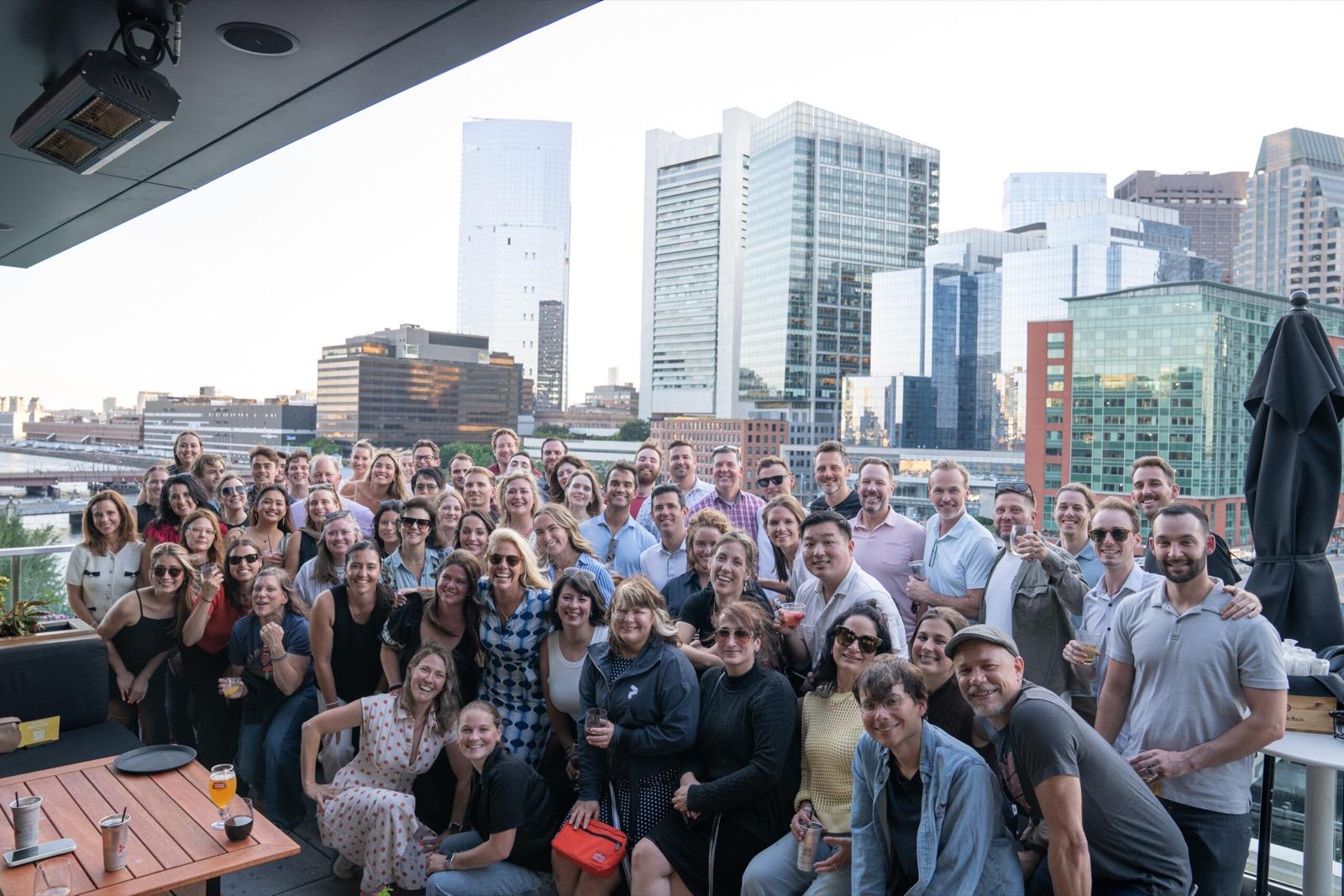 Group photo of the Pixability team on a rooftop with a city skyline behind them