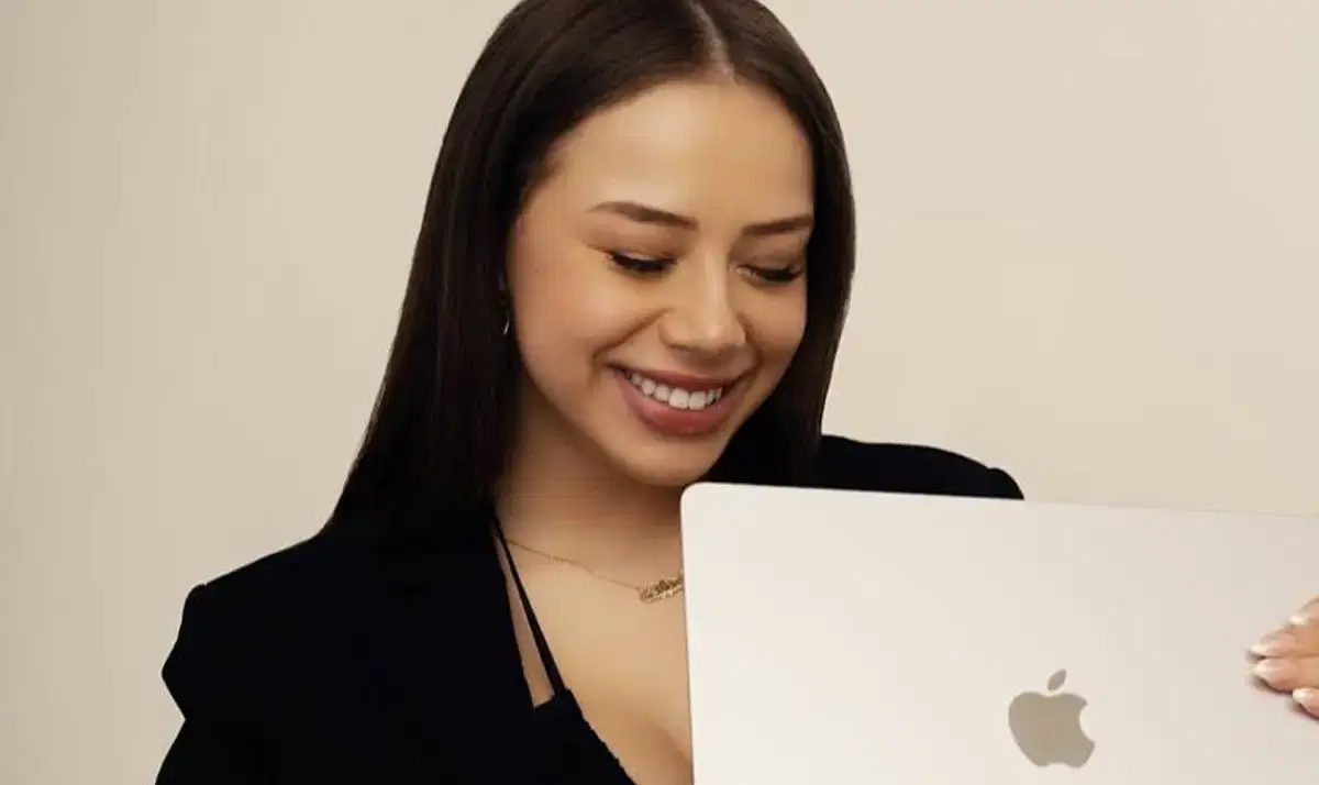 Creator smiling at her laptop