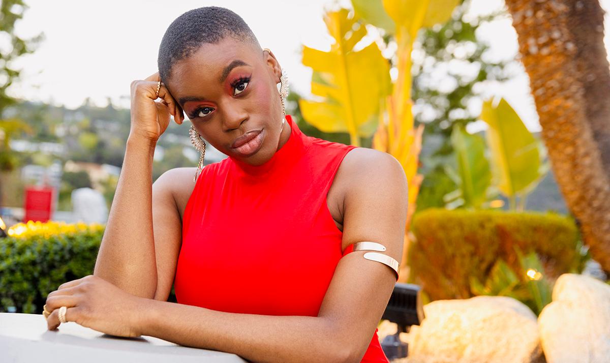 Creator posing in a red top outdoors