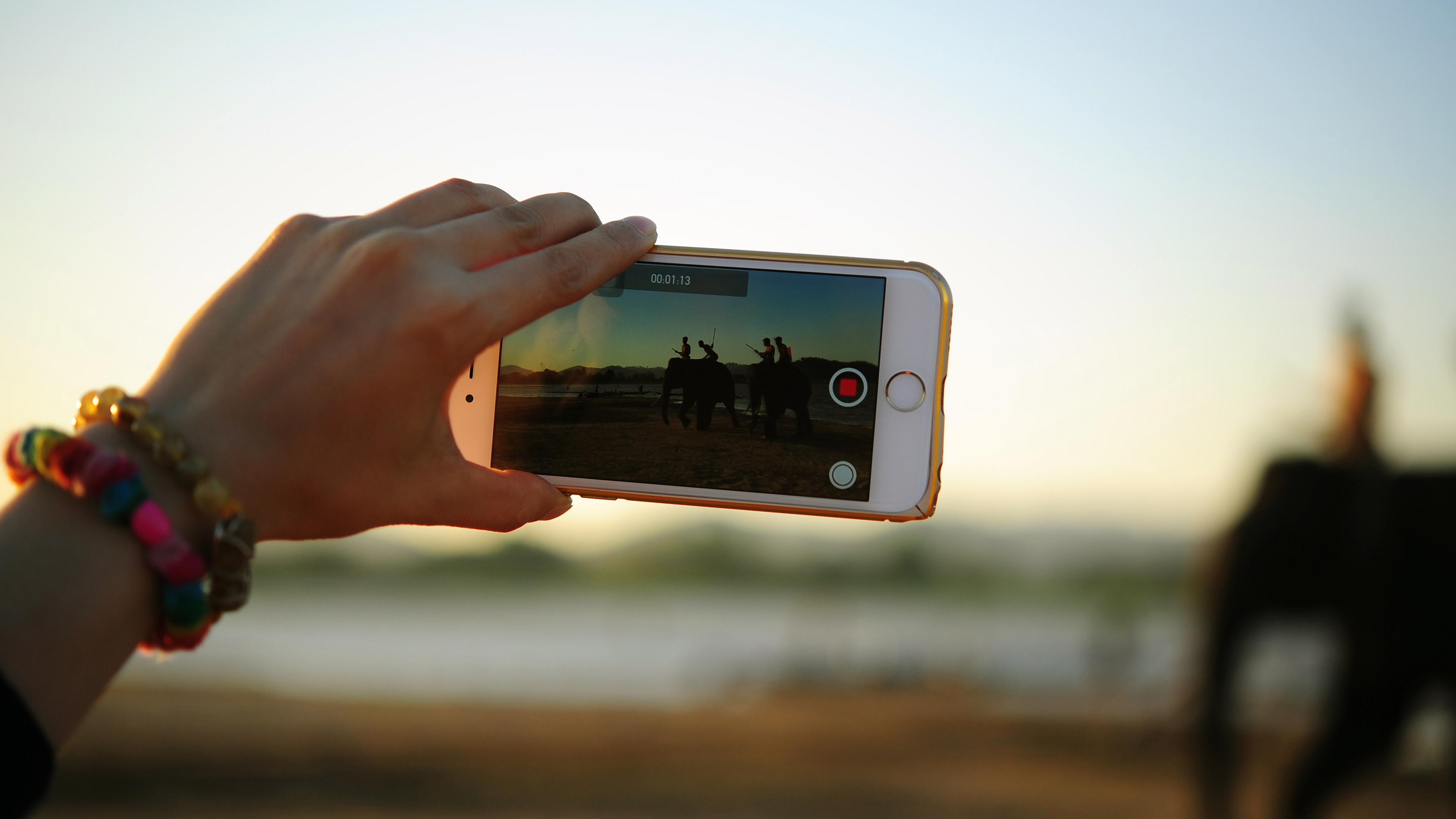 A person records video on a mobile phone.