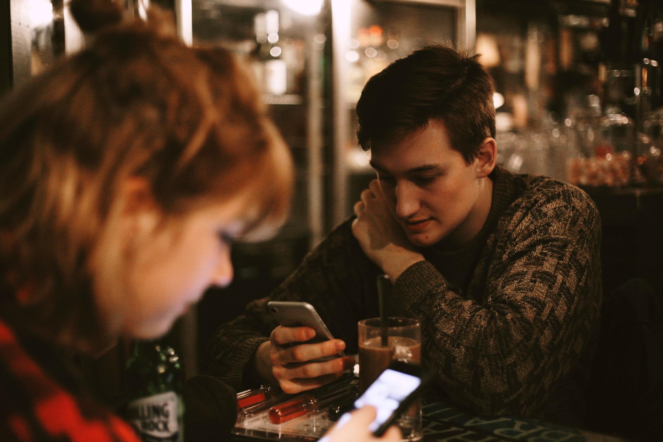 People on smartphones in a cafe