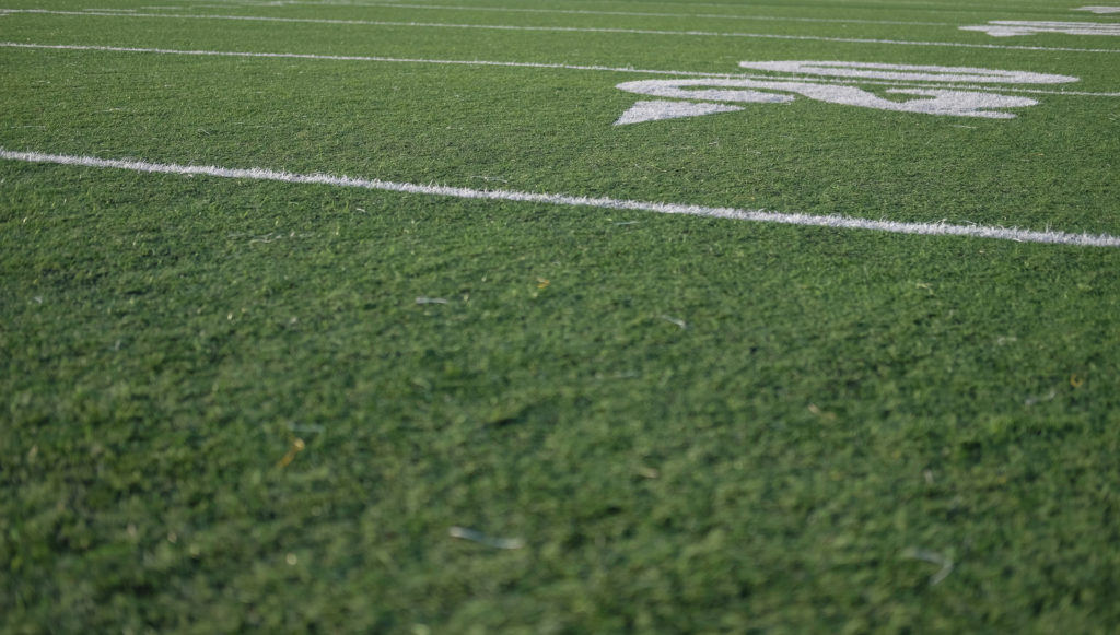 Low angle view across grassy sports field.